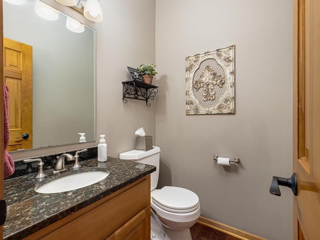 bathroom with vanity, baseboards, toilet, and wood finished floors
