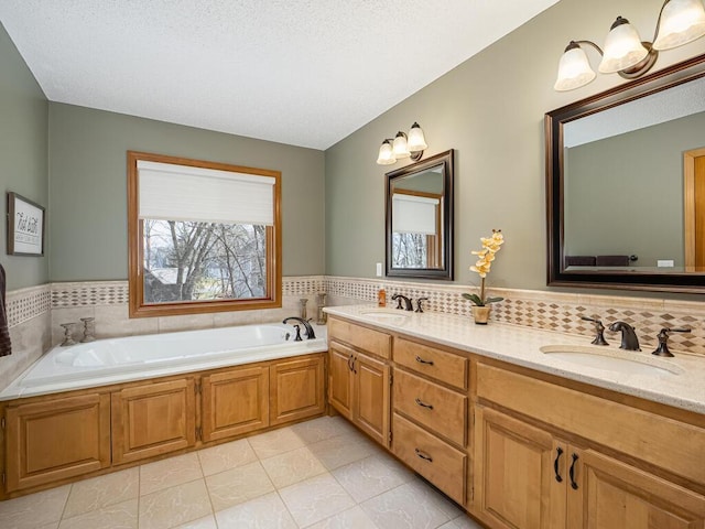 full bathroom with a sink, tile patterned flooring, double vanity, and a bath