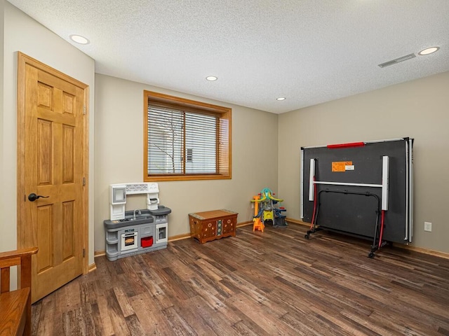 game room with a textured ceiling, recessed lighting, baseboards, wood finished floors, and visible vents