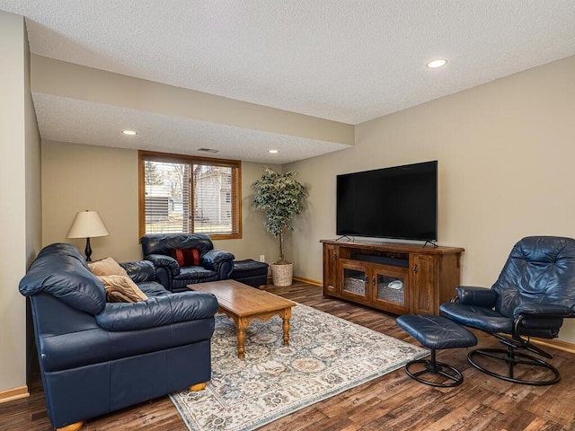 living room featuring baseboards, recessed lighting, a textured ceiling, and wood finished floors