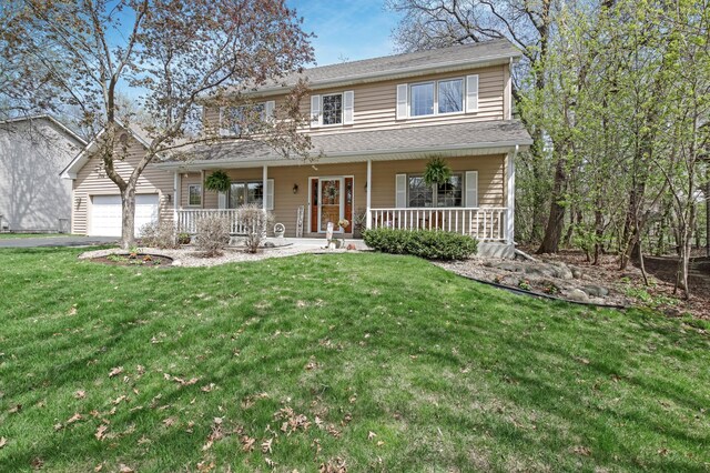 traditional-style home with a porch, an attached garage, aphalt driveway, and a front lawn