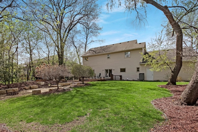 back of property featuring a lawn and central air condition unit
