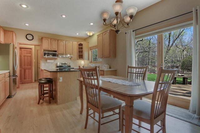 dining room featuring an inviting chandelier, light wood finished floors, and a healthy amount of sunlight