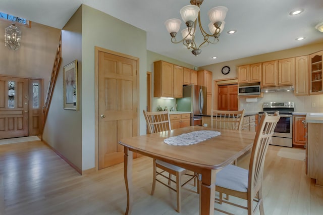 dining space with light wood-style floors, baseboards, recessed lighting, and a notable chandelier