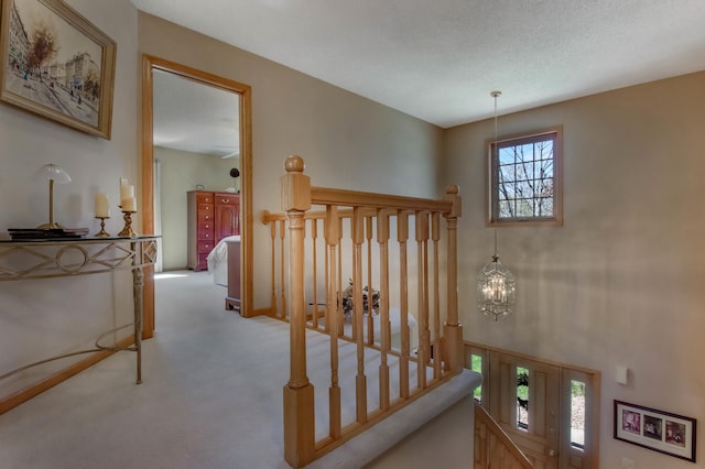 hall featuring carpet floors and a chandelier