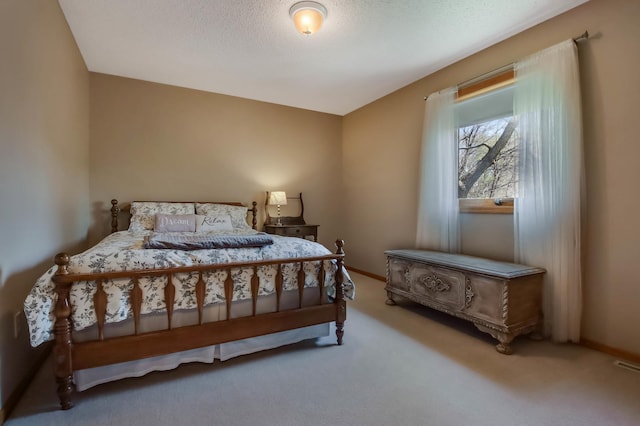 carpeted bedroom featuring a textured ceiling and baseboards