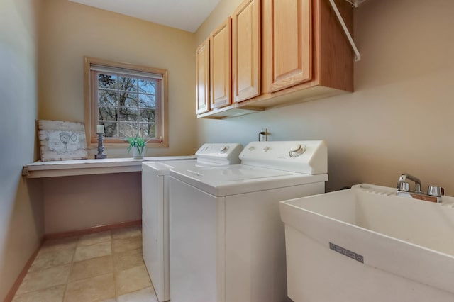 laundry room with washing machine and clothes dryer, baseboards, a sink, and cabinet space