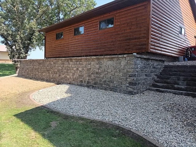 view of side of home with stairs, a patio area, and faux log siding