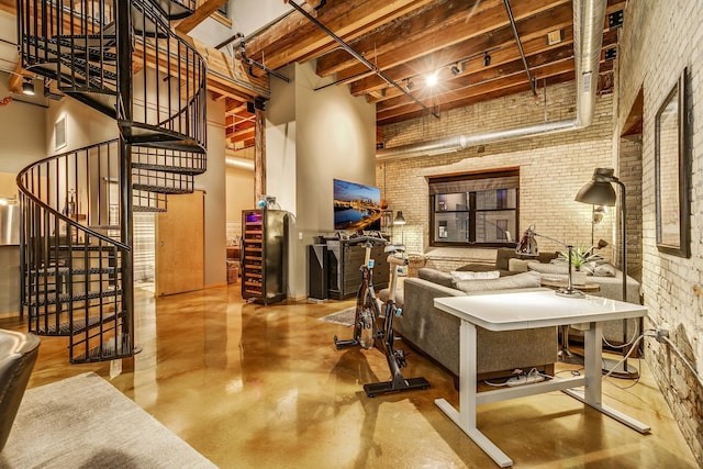 406 Wacouta St Unit 707, Saint Paul, MN 55101 - living area featuring a high ceiling, brick wall, concrete floors, beamed ceiling, and stairway