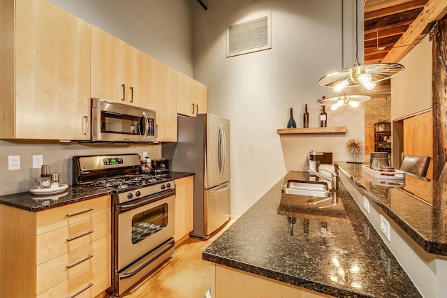 406 Wacouta St Unit 707, Saint Paul, MN 55101 - kitchen with visible vents, light brown cabinets, dark stone counters, a sink, and appliances with stainless steel finishes