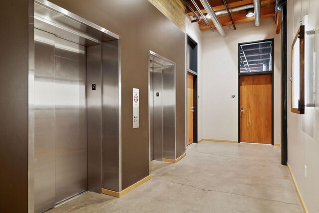 406 Wacouta St Unit 707, Saint Paul, MN 55101 - corridor featuring baseboards, concrete flooring, and elevator