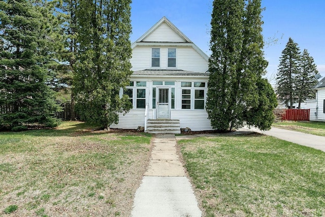 view of front of home with fence, a shingled roof, entry steps, and a front lawn