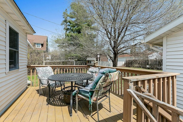 wooden terrace with outdoor dining area and a fenced backyard