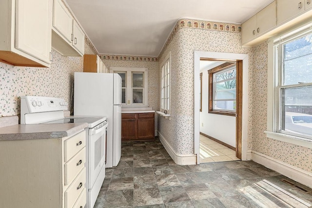kitchen with plenty of natural light, white range with electric cooktop, and wallpapered walls