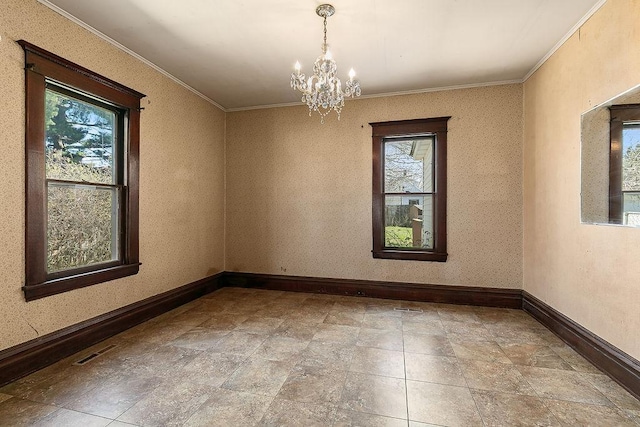empty room featuring baseboards, a chandelier, ornamental molding, and a healthy amount of sunlight