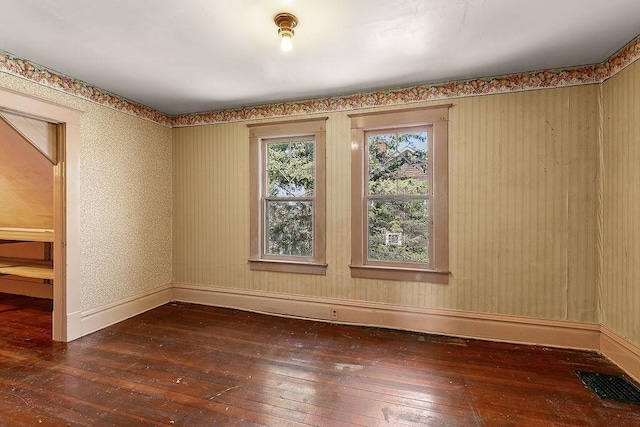 spare room with visible vents, baseboards, and hardwood / wood-style floors
