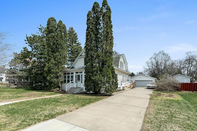 view of front of house featuring a garage, fence, an outbuilding, and a front yard