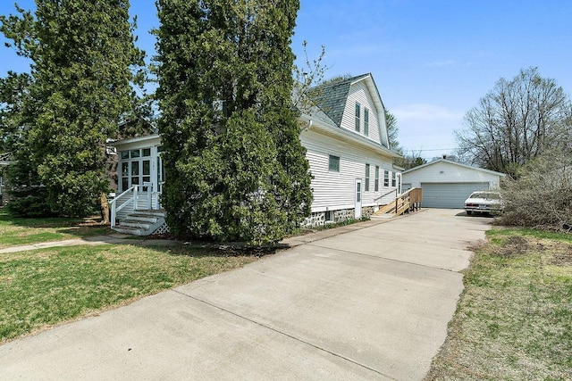 view of front facade featuring a front lawn, an outbuilding, and a detached garage