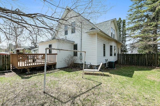 rear view of property featuring a yard, a wooden deck, a fenced backyard, and central AC unit