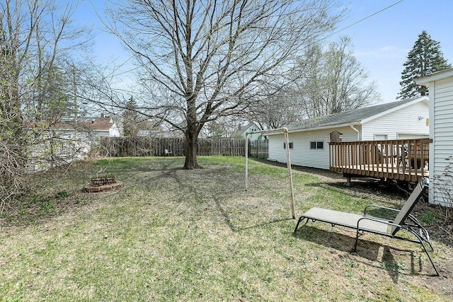 view of yard featuring fence, a wooden deck, and an outdoor fire pit