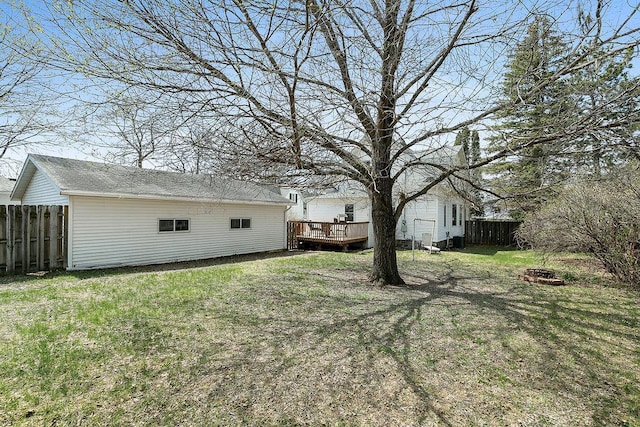 view of yard featuring a deck, a fire pit, and a fenced backyard