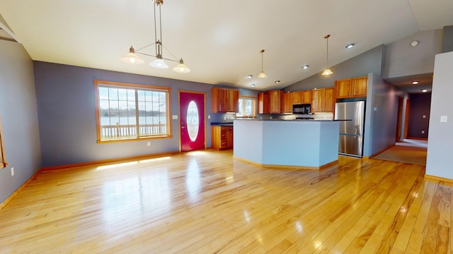 11544 Lake Eunice Rd, Detroit Lakes, MN 56501 - kitchen featuring black microwave, freestanding refrigerator, vaulted ceiling, light wood finished floors, and dark countertops