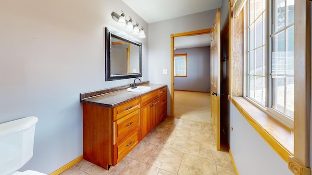 11544 Lake Eunice Rd, Detroit Lakes, MN 56501 - bathroom featuring plenty of natural light, toilet, vanity, and baseboards
