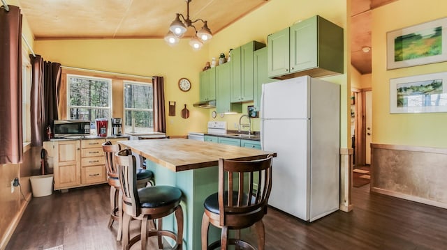 kitchen featuring vaulted ceiling, a sink, dark wood-style floors, wood counters, and white appliances