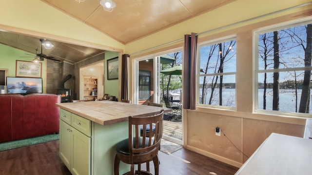 kitchen featuring a wood stove, dark wood-style flooring, wooden counters, green cabinetry, and vaulted ceiling