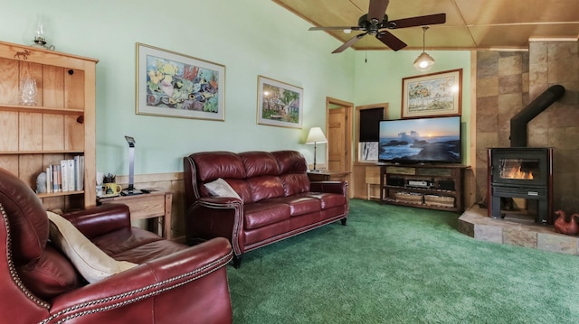 living room with carpet floors, a wood stove, and ceiling fan