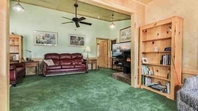 living room with carpet flooring, ceiling fan, and a wood stove