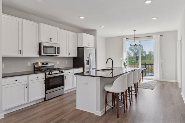 8678 London Cir NE Unit B, Blaine, MN 55449 - kitchen featuring dark countertops, stainless steel appliances, wood finished floors, and a sink