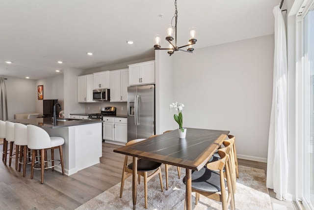 8678 London Cir NE Unit B, Blaine, MN 55449 - dining room with baseboards, light wood finished floors, an inviting chandelier, and recessed lighting