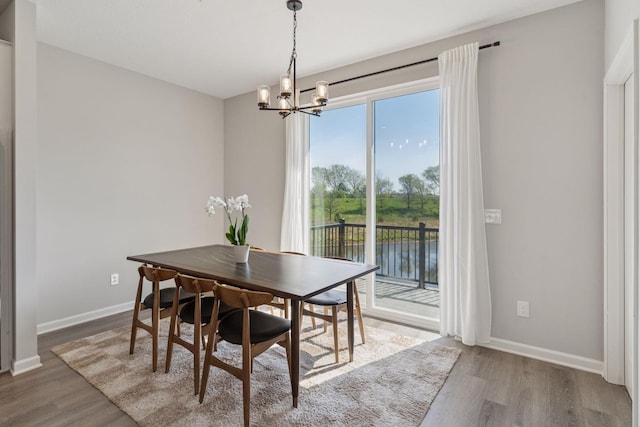 8678 London Cir NE Unit B, Blaine, MN 55449 - dining space with baseboards, a chandelier, and wood finished floors