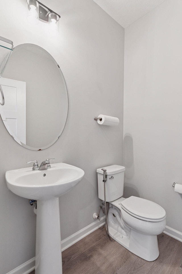 8678 London Cir NE Unit B, Blaine, MN 55449 - bathroom featuring toilet, wood finished floors, and baseboards