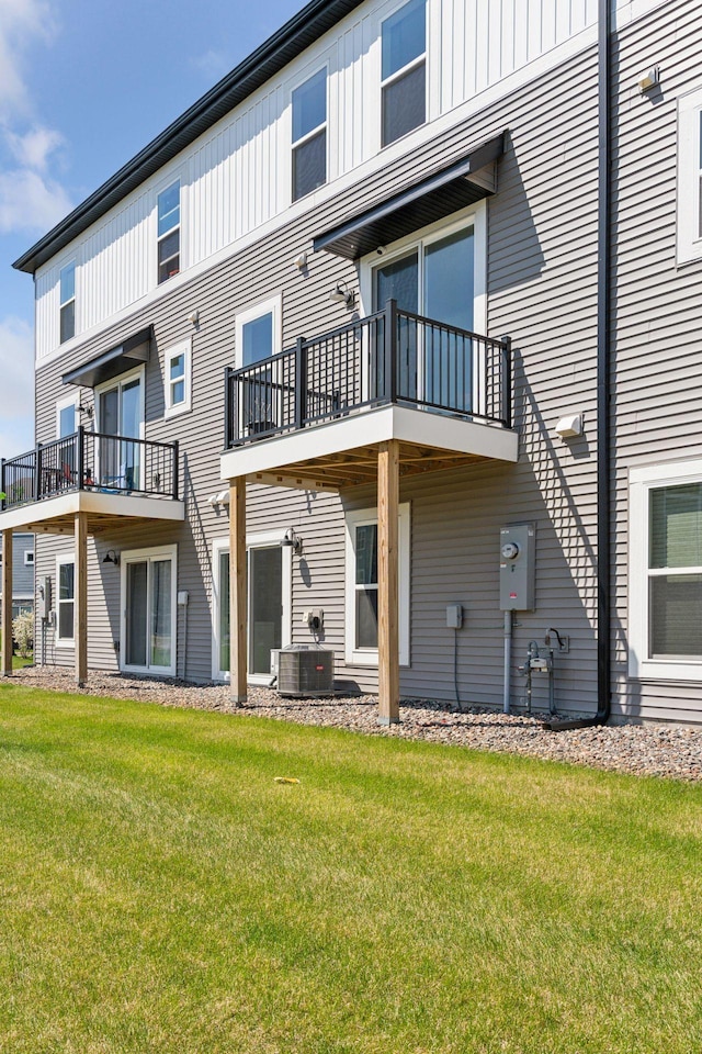 8678 London Cir NE Unit B, Blaine, MN 55449 - back of property with cooling unit, board and batten siding, a yard, and a balcony