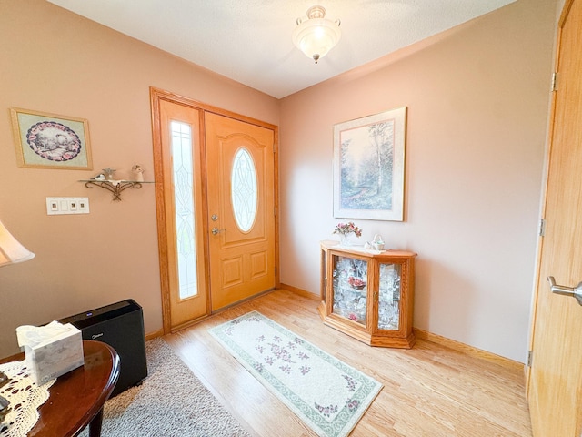 foyer featuring baseboards and light wood-style flooring