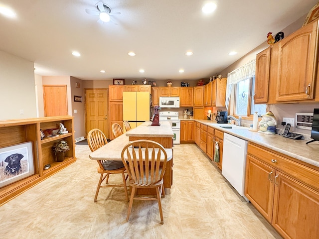 kitchen featuring white appliances, recessed lighting, a sink, and light countertops