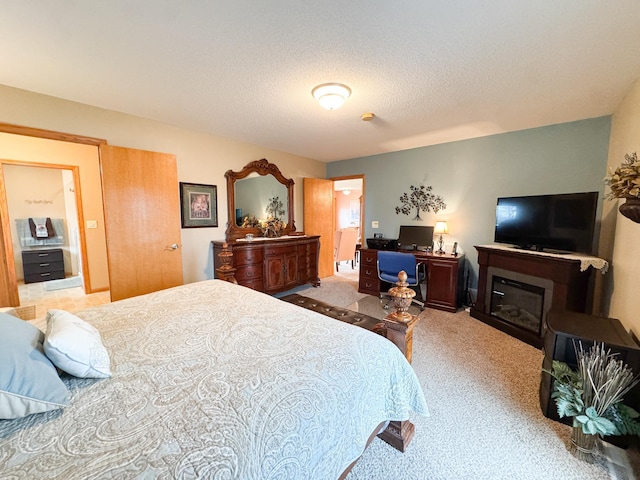 bedroom with carpet floors and a glass covered fireplace