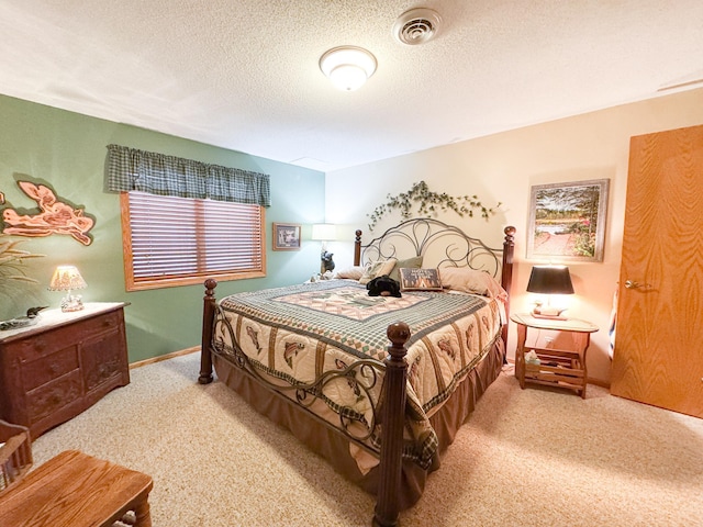 carpeted bedroom with baseboards, a textured ceiling, and visible vents