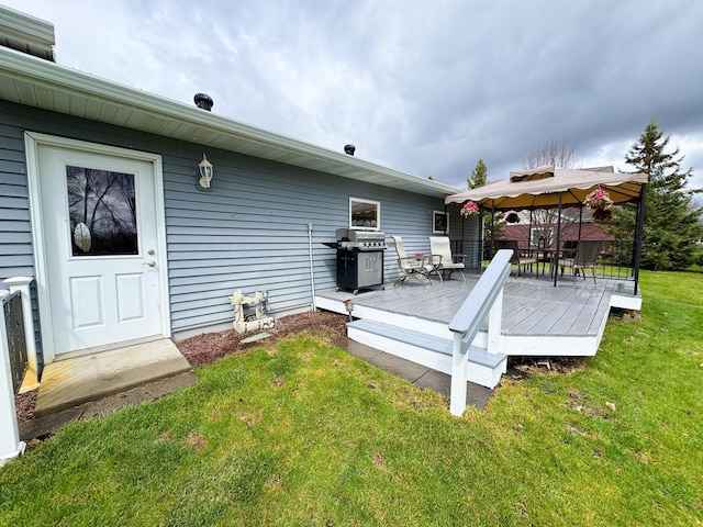 rear view of house featuring a gazebo, a yard, and a deck