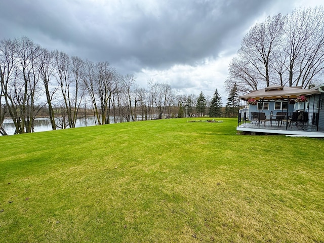 view of yard with a gazebo and a deck with water view