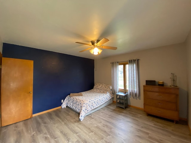 bedroom with baseboards, ceiling fan, and light wood finished floors