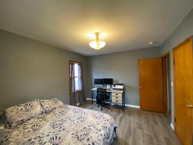 bedroom with baseboards and wood finished floors
