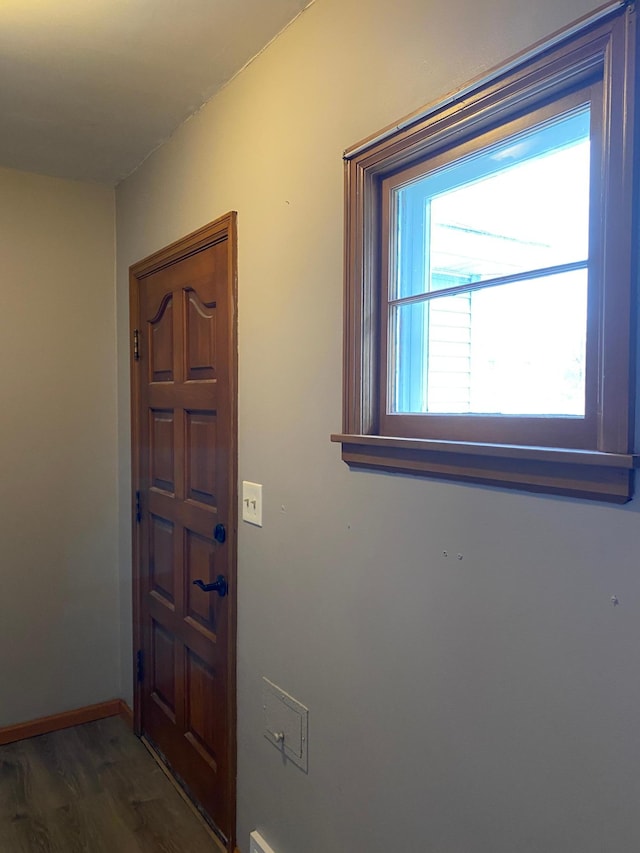 foyer entrance featuring baseboards and wood finished floors