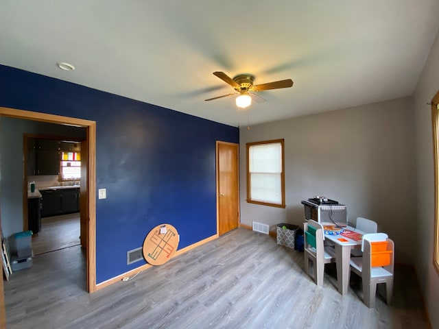 misc room with a ceiling fan, wood finished floors, and visible vents