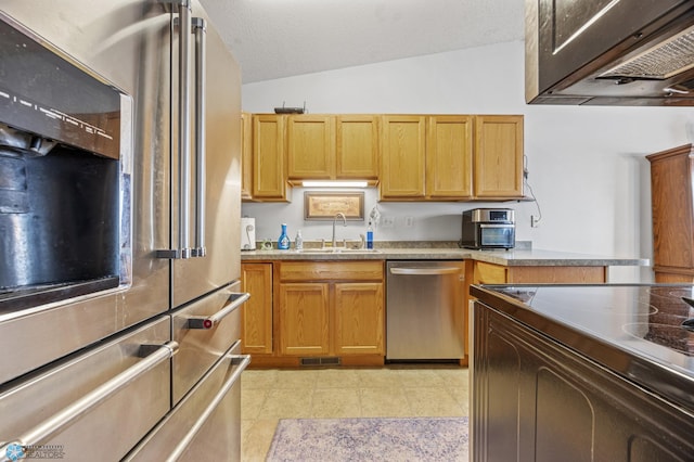 kitchen with visible vents, lofted ceiling, light countertops, a sink, and appliances with stainless steel finishes