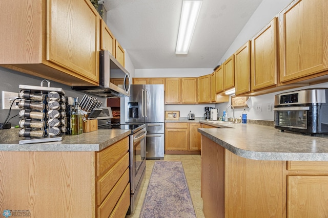 kitchen with light brown cabinetry, stainless steel appliances, vaulted ceiling, and a sink