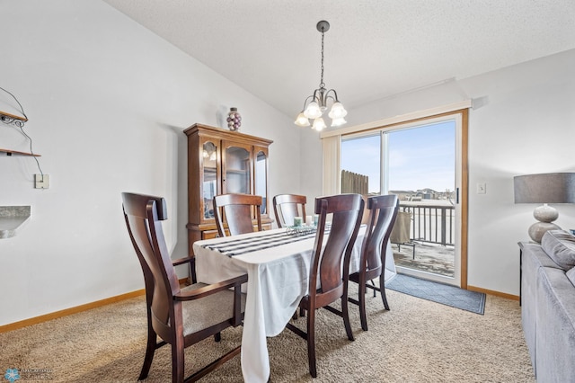 dining area featuring an inviting chandelier, baseboards, vaulted ceiling, and light colored carpet