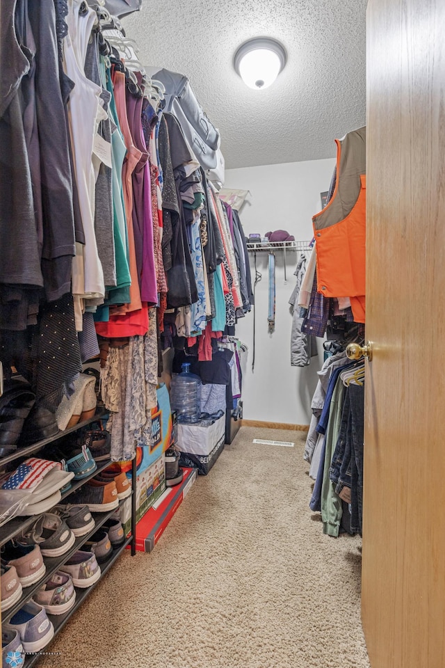 walk in closet with carpet floors